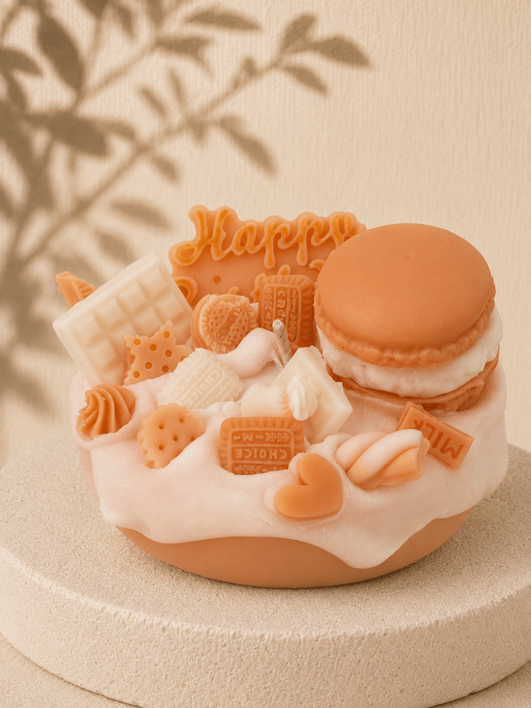 Cream Crush cake-style scented soy candle in cream and white with macaron, chocolate bars, biscuits, hearts and sweet-inspired wax decorations