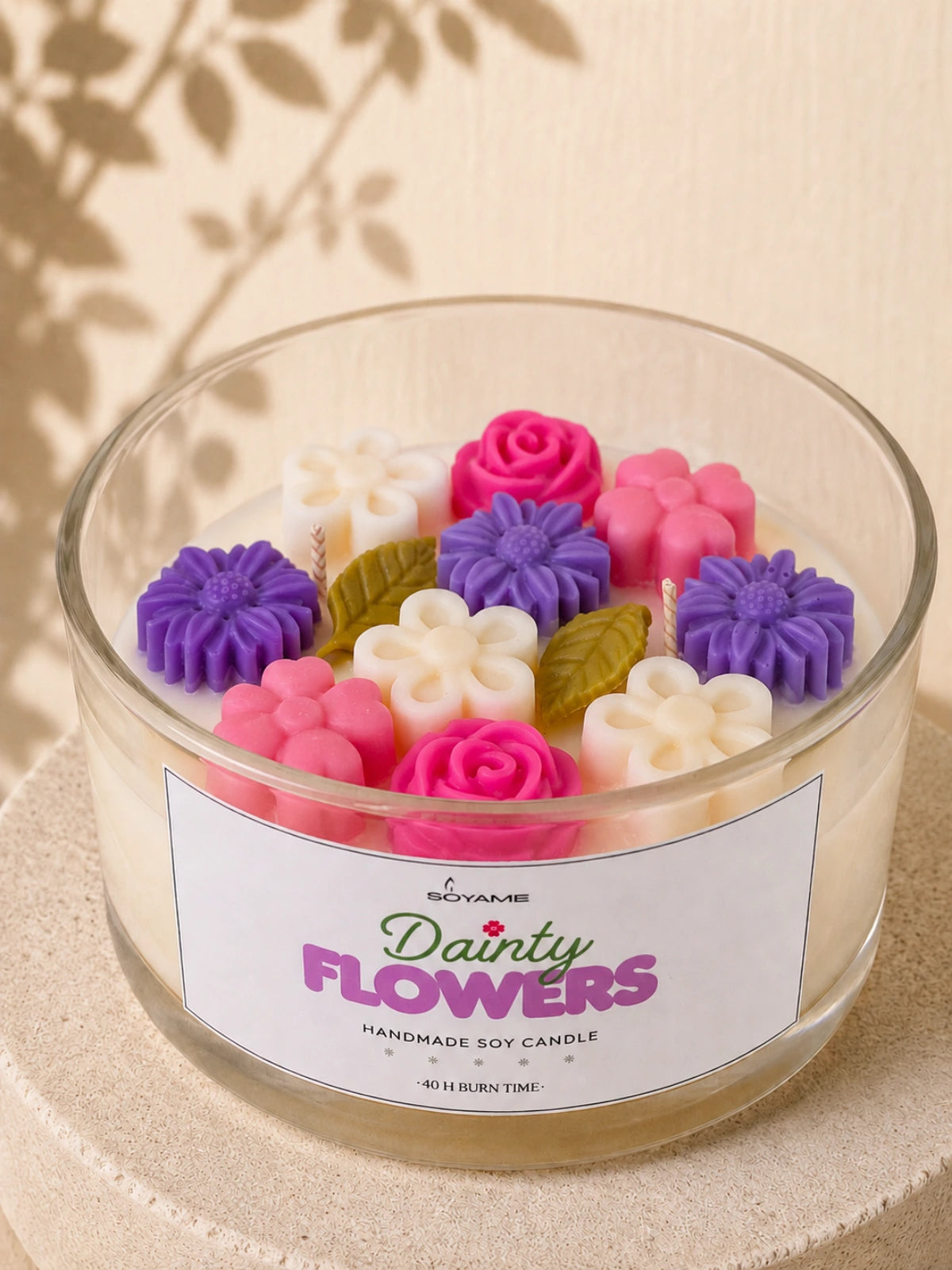Close-up of colourful pink, purple and white wax flowers on a Dainty Flowers soy candle