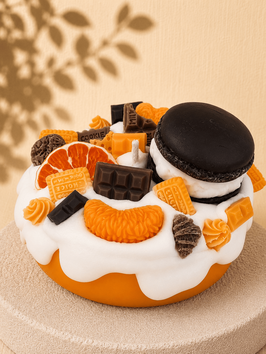 Orange Crush cake-style scented candle with an orange base, white frosting and orange and brown wax decorations