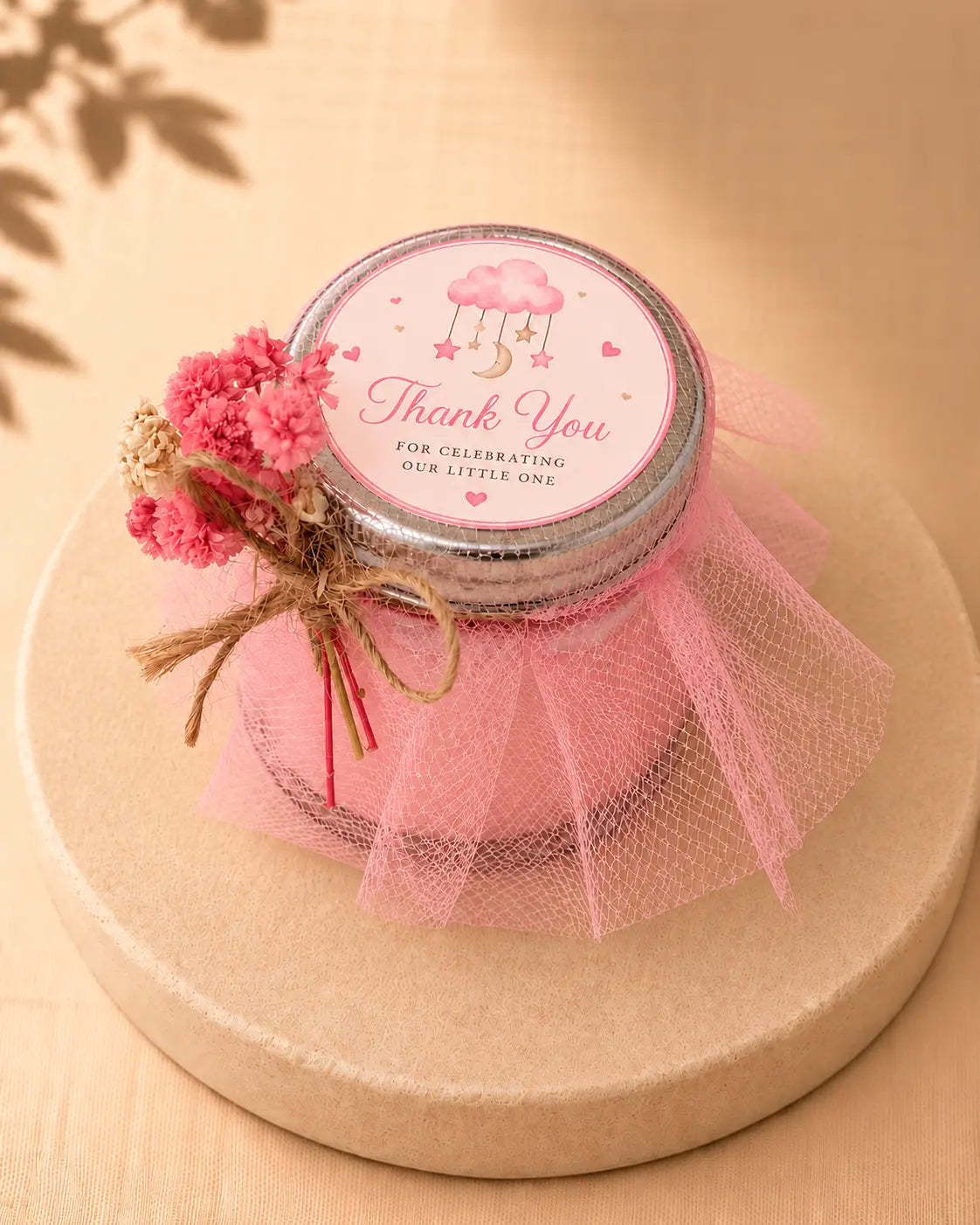 Pink baby shower candle favour with personalised labels and decorative details