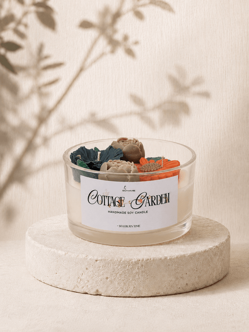 Cottage Garden scented soy candle with colourful floral wax decorations in a clear glass jar