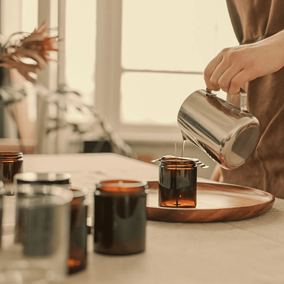 Hand-pouring candles in the SOYAME studio as part of our small-batch candle making process.