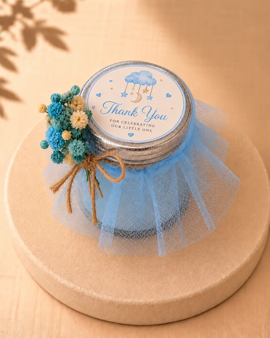 Blue personalised baby shower candle favour with a thank-you label and dried flower decoration