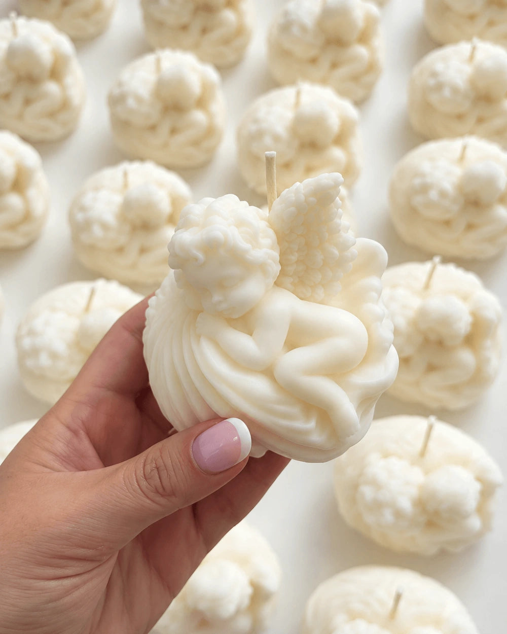 White angel-shaped candle favours with detailed wings and sculpted design