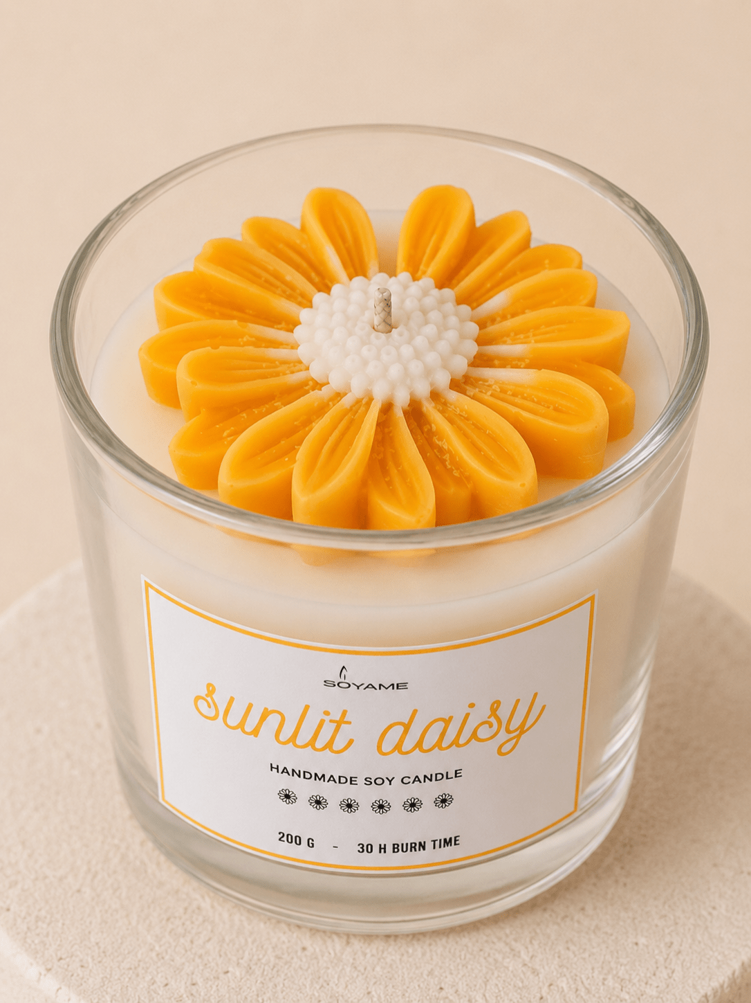 Close-up of Sunlit Daisy scented soy candle with yellow and white daisy wax flower